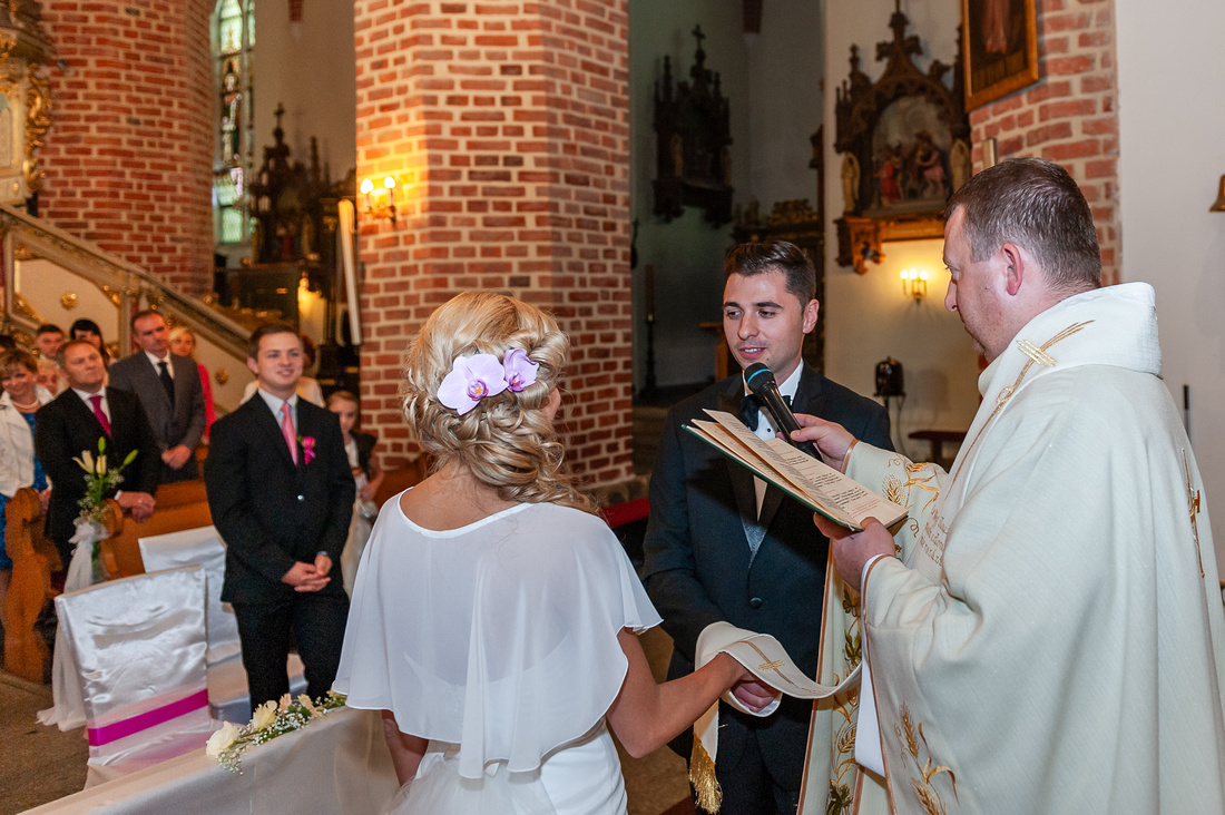 Pan Młody wypowiada słowa przysiegi małżeńskiej w kościele w Pucku